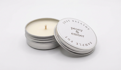 Candle sample in a tin labelled 'Just Breathe' with the brand name 'Peony & Ember' in the middle on a white background